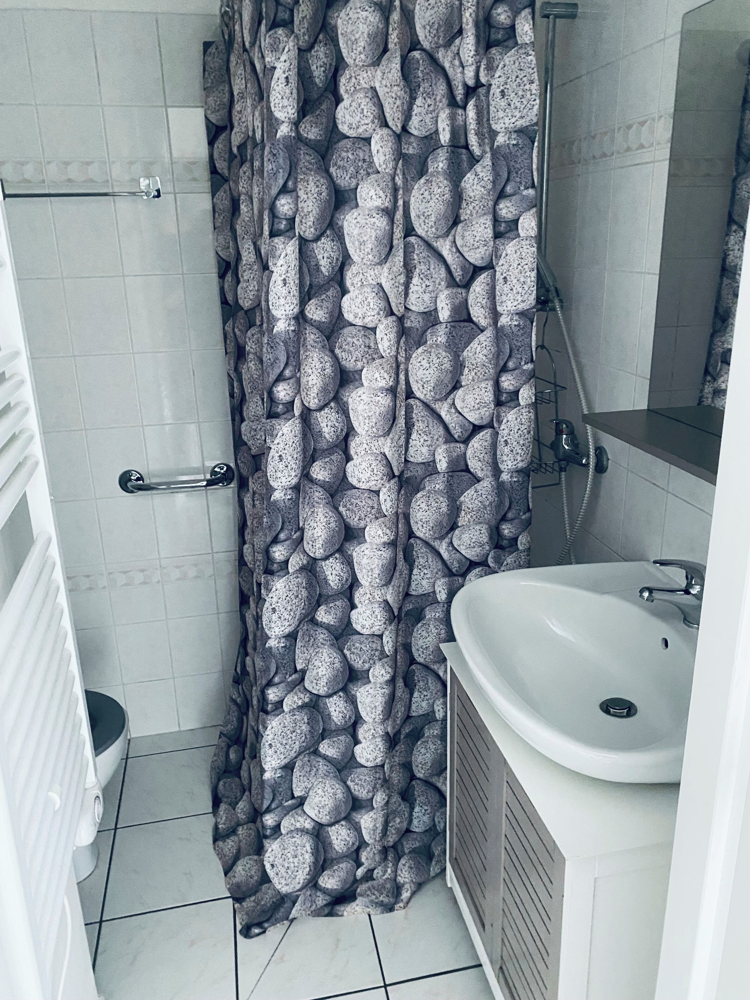 Een douche, handdoeken, zeep, toiletpapier