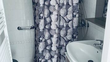 Een douche, handdoeken, zeep, toiletpapier