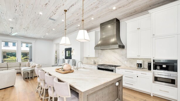A modern kitchen with a large island, white cabinetry, and a wooden ceiling. - Gulf Views with LSV, Pool, Peloton & More (Santa Rosa Beach)
