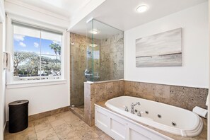 Ein Badezimmer mit Badewanne, einer Duschkabine aus Glas, einem Fenster mit Blick und einem Bild an der Wand.