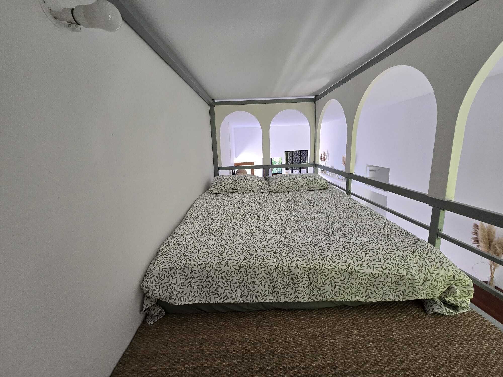Une chambre avec un lit, une fenêtre et un balcon.