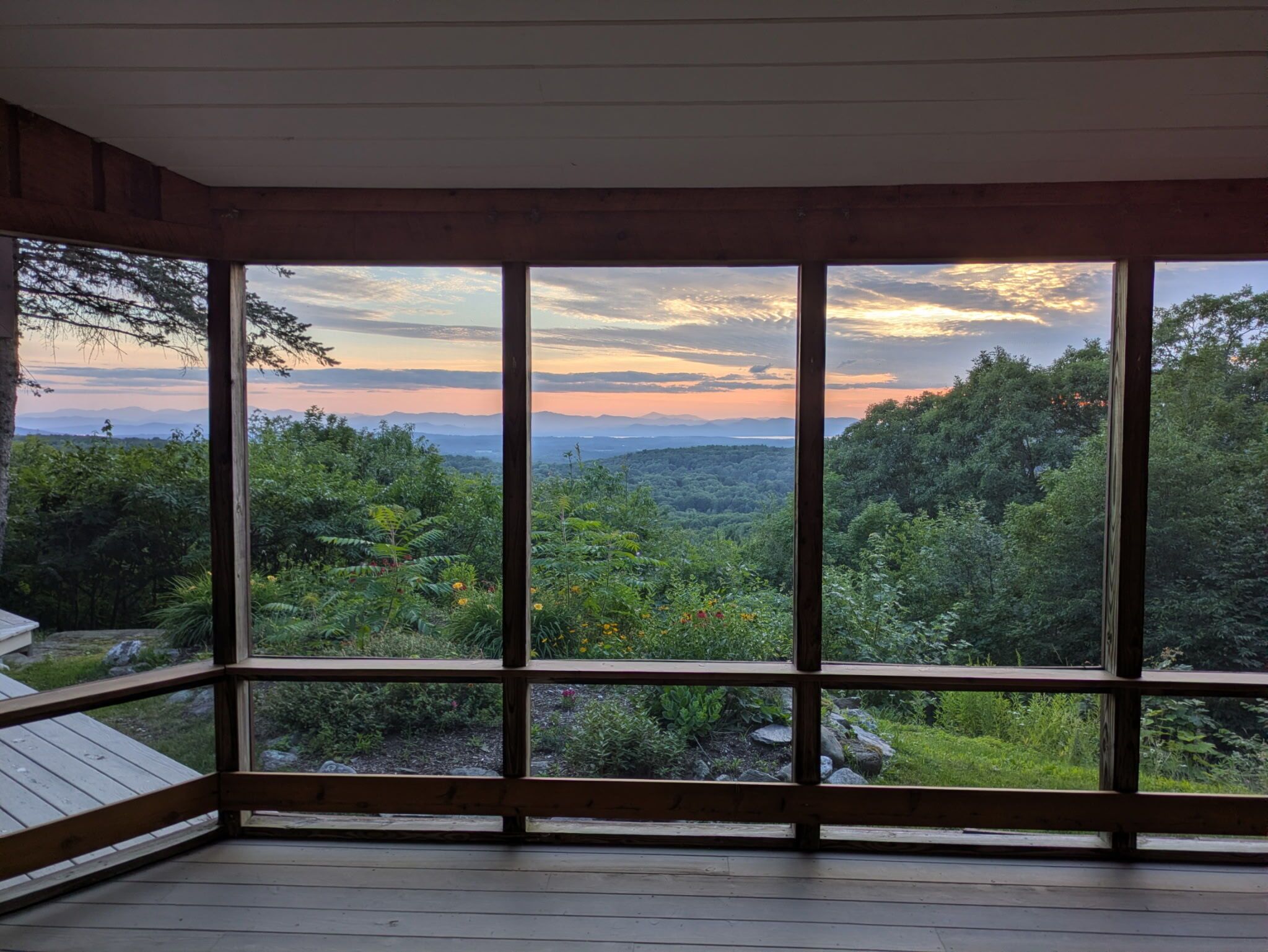 Una habitación con ventanas amplias que ofrecen vistas a un paisaje boscoso.