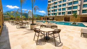 A resort pool area with outdoor seating, a pool, and a mountain backdrop. - Apartamentos Reserva-Bellohorizonte SOHO (Bello Horizonte)