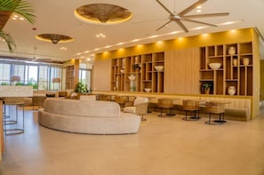 A modern interior with a seating area, a bar, and a ceiling fan. - Apartamentos Reserva-Bellohorizonte SOHO (Bello Horizonte)