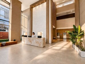 A spacious lobby with a reception desk, large windows, and a modern design. - Apartamentos Reserva-Bellohorizonte SOHO (Bello Horizonte)