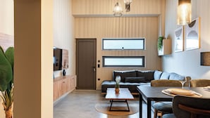 Un salon moderne avec un canapé, une table à manger et un téléviseur.