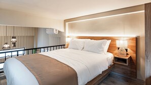 Une chambre d’hôtel moderne avec un grand lit, une table de chevet et une vue sur le balcon.