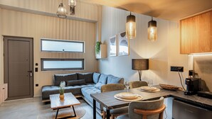 Un salon moderne comprenant un canapé, une table à manger et un coin cuisine.