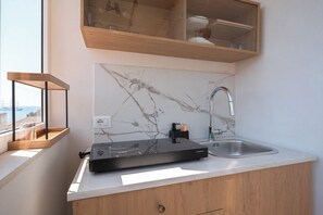 A kitchen with a marble backsplash, a built-in sink, and a wooden countertop. - INTERNAL VJ (Giardini Naxos)