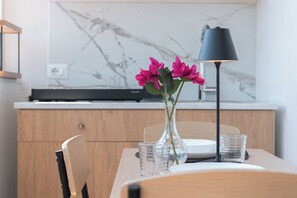 A dining table with a vase of flowers, a lamp, and a glass of water. - INTERNAL VJ (Giardini Naxos)