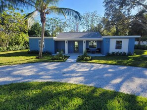 A modern two-story house with a gravel driveway, a front porch, and a well-maintained lawn. - Navigate Stays West Palm Beach 4BR Family Retreat (West Palm Beach)