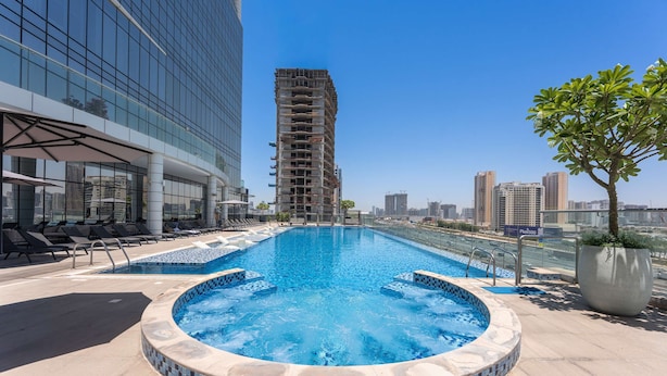 A rooftop pool with a hot tub, lounge chairs, and a view of a city skyline. - Free Housekeeping Visits During Your Stay - Stayshort - Stunning Studio in JVT Sleeps 2 With Balcony (Dubai)
