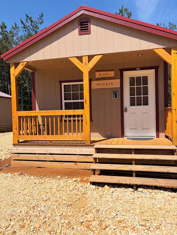 A wooden building with a red roof, a porch with wooden railings, and a door labeled 'BASS BUNKER.'