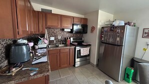 A kitchen with wooden cabinets, a microwave, stove, and refrigerator. - Peaceful 2-bedroom townhome with AC in charming Tucson (Tucson)