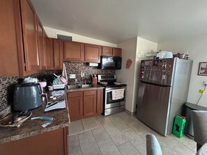 A kitchen with wooden cabinets, a microwave, stove, and refrigerator. - Peaceful 2-bedroom townhome with AC in charming Tucson (Tucson)