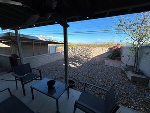 A covered patio area with outdoor seating, a gravel ground, and a view of a distant landscape. - Peaceful 2-bedroom townhome with AC in charming Tucson (Tucson)
