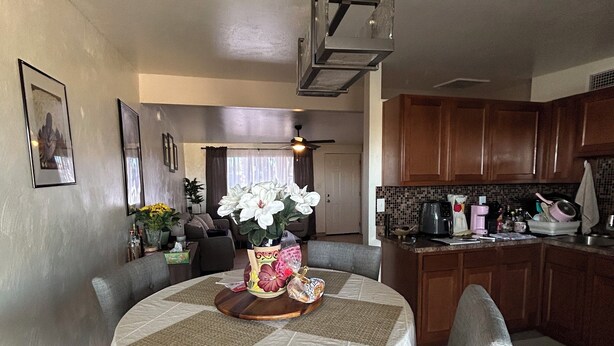A dining area with a round table, chairs, and a kitchen in the background. - Peaceful 2-bedroom townhome with AC in charming Tucson (Tucson)