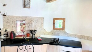 Een keuken met een houten plafond, een ronde tafel en een stoel.