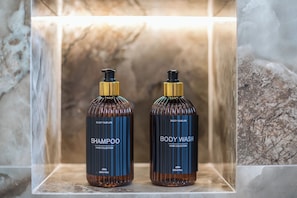 Zwei Flaschen Shampoo und Duschgel in einem Badezimmer.
