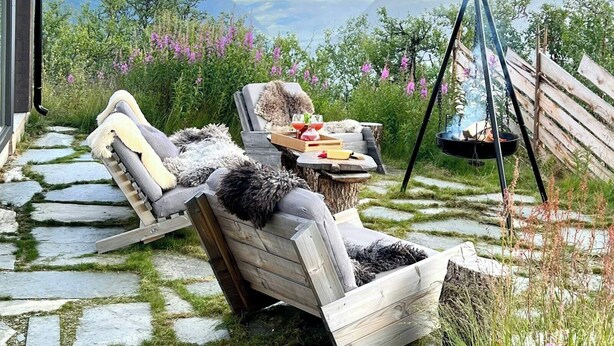 A patio with two lounge chairs, a table with drinks, and a hanging fire pit. - Charming moutain cabin with charm near Vasstulan (Uvdal)