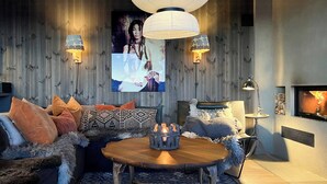 A cozy living room with a sofa, a wooden coffee table, and a fireplace. - Charming moutain cabin with charm near Vasstulan (Uvdal)