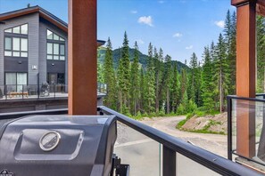 A modern building with large windows and a view of a forested mountain area. - Stylish 3BR at Panorama Resort / Hot Tub Retreat (Panorama)