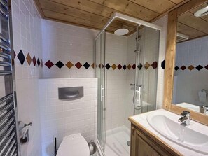 A bathroom with a glass shower enclosure, a white sink, and a toilet. - Up to 10 meters from the ski slope, 2nd floor, terrace, parking, TV, 80 m², Peisey-Vallandry (Landry)