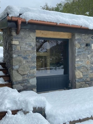 A stone building with a dark door and a small window. - 1st floor, sauna, terrace, fireplace or stove, tv, 180m², Montchavin La Plagne (Landry)