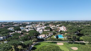 A residential area with white buildings, a swimming pool, and green lawns. - Golfemar - Vilamoura Golf Area Townhouse w/ Pool · A/C · WiFi · Garage (Quarteira)