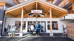 En træbygning med et skilt, der siger 'SHOP' over indgangen.