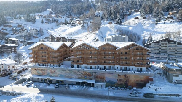 A multi-story wooden building with balconies, surrounded by snow-covered terrain and trees. - Wi-Fi, 20 meters from the ski slopes, valley view, patio, balcony, TV, 35–40 m², La Tzoumaz (La Tzoumaz)