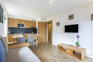 A modern apartment with a kitchen, dining area, and a living room with a TV and a plant. - Wi-Fi, 50 meters from the resort center, valley view, patio, balcony, TV, 46–50 square meters, La Tzoumaz (La Tzoumaz)