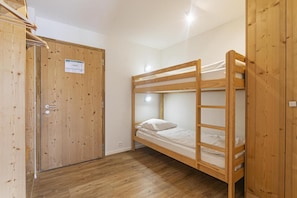 A bunk bed room with wooden walls and a wooden door. - Wi-Fi, 50 meters from downtown, patio, balcony, TV, 72–91 square meters, La Tzoumaz (La Tzoumaz)