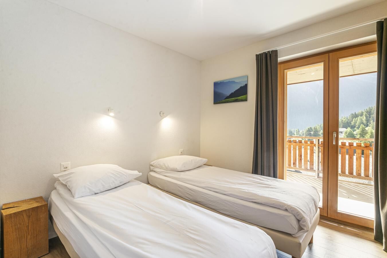 A room with two beds, a painting, and a view through a sliding door.