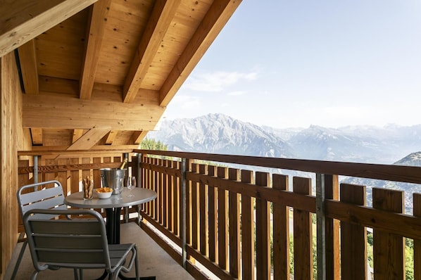 A wooden balcony with a table and chairs, overlooking a mountainous landscape. - Wi-Fi, 50 meters from the resort center, valley view, terrace, balcony, TV, 72–85 square meters, La Tzoumaz (La Tzoumaz)