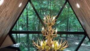 Ein Zimmer mit großem Fenster und Blick auf einen Wald.
