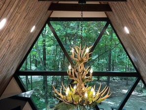 Ein Zimmer mit großem Fenster und Blick auf einen Wald.