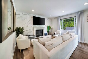 A modern living room with a fireplace, a flat-screen TV, and a sofa. - The Stagg Lane Retreat (Los Angeles)