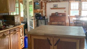 Una cocina con armarios de madera, una isla central y cuadros en las paredes.