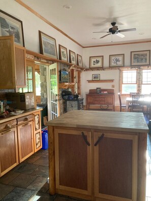 A kitchen with wooden cabinets, a central island, and framed pictures on the walls. - Gorgeous 3-bedroom 3 bath Craftsman home north of Mt. Washington (Stark)