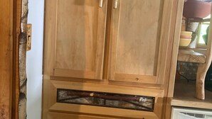 Un mueble de madera con dos cajones y un refrigerador integrado.