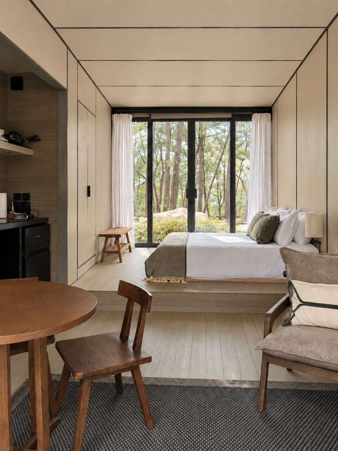 Un dormitorio moderno con una cama grande, un escritorio y una mesa de comedor.