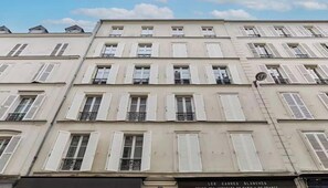 A multi-story building with white facades, shutters, and balconies. - COMBINING COMFORT, STYLE & AN EXCEPTIONAL LOCATION IN THE PRESTIGIOUS 7TH ARR (Paris)