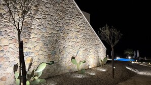 A stone building with a sloped roof, a pool, and a few trees. - Sea-view apartment with a pool (Telegrafo)