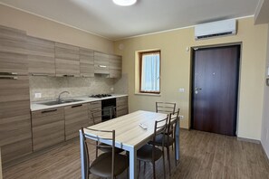 Cozinha moderna com mesa de jantar, armários e janela.