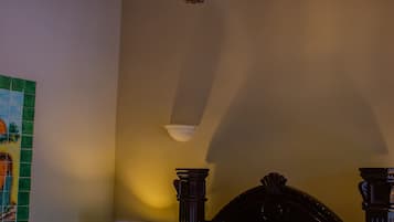 Une chambre à coucher comprenant un lit, une table de chevet, une lampe et un luminaire suspendu.