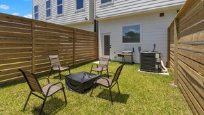 Ein Garten mit Holzzaun, Grill und Gartenmöbeln.