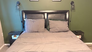 Ein Bett mit Kopfteil, zwei Nachttische und zwei Wandlampen.