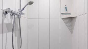 Een douche, een haardroger, handdoeken, toiletpapier