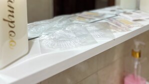 A bathroom counter with toiletries and a mirror.